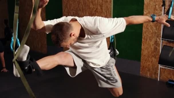 Fit όμορφο νεαρό άνδρα κάνει fly yoga τεντώνοντας ασκήσεις με trx ιμάντες γυμναστικής στην προπόνηση φυσικής κατάστασης — Αρχείο Βίντεο