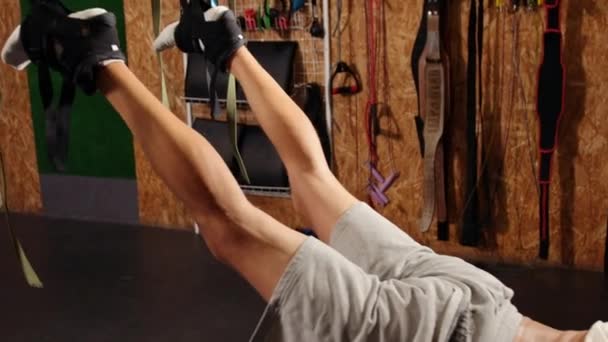 A trabalhar muito. Vista lateral do homem atlético, corpo perfeito em sportswear pendurado no ar com trx fitness — Vídeo de Stock