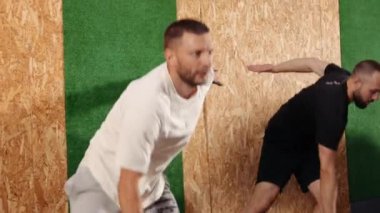 Formda vücut egzersizi yapan erkek sporcu. Şık spor kıyafetleri içinde çekici bir adam. Dinamik hareket. Spor, sağlıklı yaşam tarzı. Mutlu, çekici, yakışıklı, formda spor kıyafetleri giyen modern erkekler.