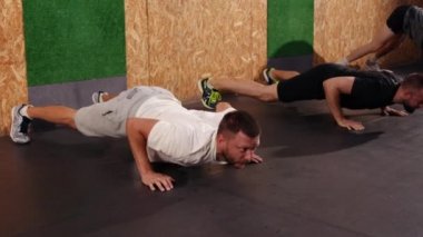 Spor salonunun iç kısımlarında spor yaparken esnek ve sağlıklı erkekler spor yapıyor. Çekici, güzel bir şekilde eğiliyor. Formda olan genç adam içeride forvet oynuyor. Etkin yaşam tarzı kavramı