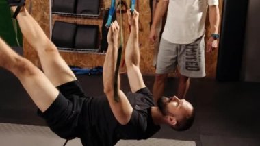 Antrenör monitörleri egzersizi. Spor salonunda kolları trakeostomi bandıyla çalıştıran erkekler göğüs üst omuzlarında göğüs kasları üzerinde şınav çekiyorlar. Spor salonunda egzersiz yapan insanlar, beden eğitimi kavramı