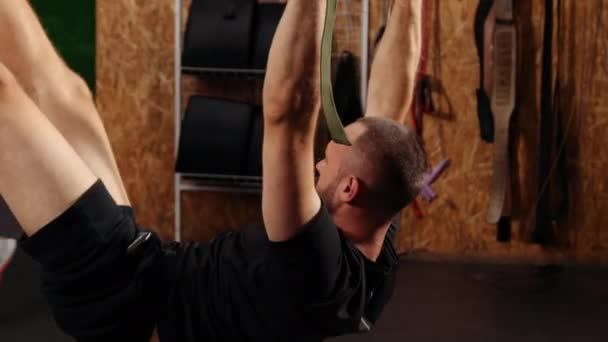 男人们在体育馆里练习带桁架健身带的胳膊 做俯卧撑 在空中训练上身胸部胸肌三头肌 人们在健身房锻炼 体育观念 训练员监测训练 — 图库视频影像