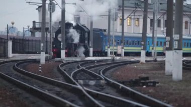 Klasik siyah buhar lokomotifi. Tarihi bir tren. Araç lokomotifi tren istasyonundan ayrılıyor. Eski buhar treni tren istasyonundan ayrılıyor..