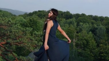 Vahşi kadın elbise sallar, güneşe bakar. Dışarıdaki mavi elbiseli kadın portresi. Çöldeki bir dağın tepesinde, gök mavisi bir elbise giymiş şık bir kız. Giysiler içinde güzel hüzünlü bir kadın kaya üzerinde yürüyor.