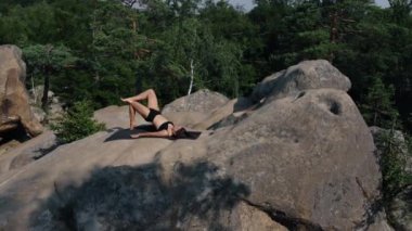 Güzel bir kadın mindere uzanır, leğen kemiğini, vücudunu, bacaklarını kaldırır. Spor, sağlık ve sağlık kavramı. Genç, gülümseyen bir bayan spor yapıyor, zinde bir kadın..