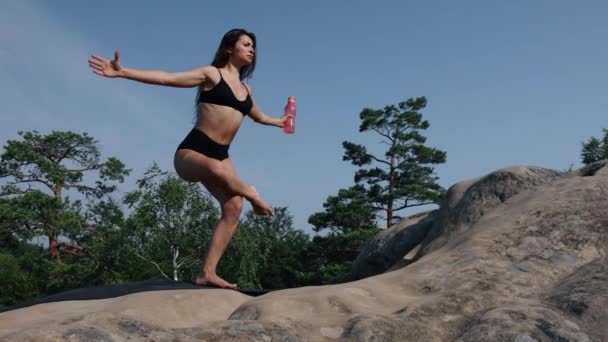 Όμορφη Γυναίκα Που Ισορροπεί Στο Ένα Πόδι Περνάει Μπουκάλι Από — Αρχείο Βίντεο