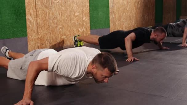 Δυνατοί Και Γυμνασμένοι Αθλητικοί Άνδρες Που Κάνουν Ασκήσεις Push Ένα — Αρχείο Βίντεο