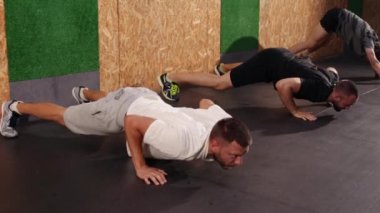Mutlu adamlar spor yapıyor, öne eğiliyor ve esniyorlar. Spor salonunda egzersiz yapıyorum. Fitness egzersizi, sağlıklı yaşam tarzı sporları. Adam içeride esneme hareketi yapıyor..