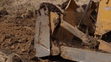 İnşaat makineleri, buldozer yapımı, toprak taşıma makinesi teknolojisi, endüstriyel ereksiyon kavramı. İnşaat alanında çamurda çalışan bir buldozer. Kapat.