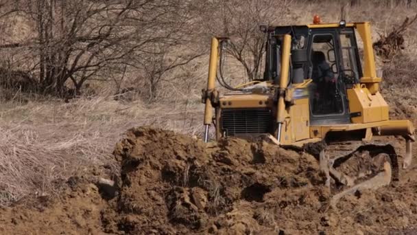 Bulldozer Bouwplaats Gooit Grond Een Hoop Krachtige Gele Grondverzetter Verkruimelt — Stockvideo