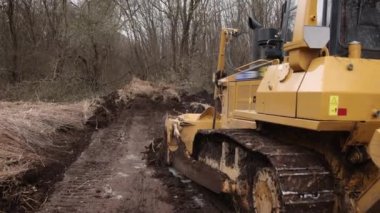 İnşaat makineleri, buldozer yapımı, toprak taşıma makinesi teknolojisi, endüstriyel ereksiyon kavramı. İnşaat alanında çamurda çalışan buldozer.