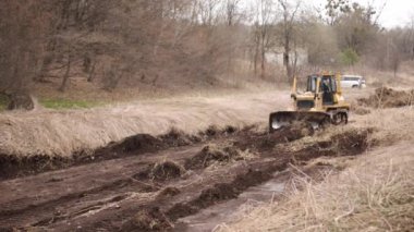 İnşaat makineleri, buldozer yapımı, toprak taşıma makinesi teknolojisi, endüstriyel ereksiyon kavramı. İnşaat alanında çamurda çalışan buldozer.