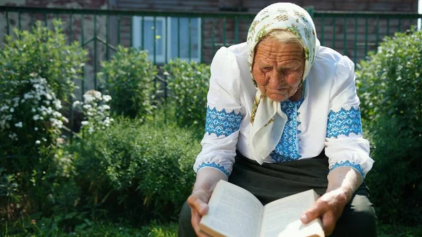 Eine Alte Großmutter Sitzt Auf Der Straße Und Liest Ein — Stockfoto