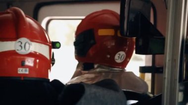 Close up portrait of strong serious firemen in helmet. Concept of saving lives, heroic profession, fire safety. Rescue team of firefighters goes to crash. Indoor the cabin
