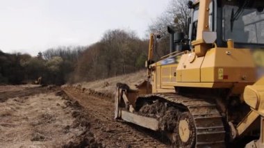 İnşaat makineleri, buldozer yapımı, toprak taşıma makinesi teknolojisi, endüstriyel ereksiyon kavramı. İnşaat alanında çamurda çalışan buldozer.
