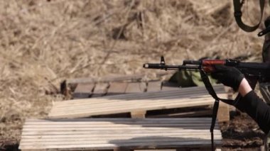 On a shooting range, a men is using a machine gun to fire a target at the shooting range