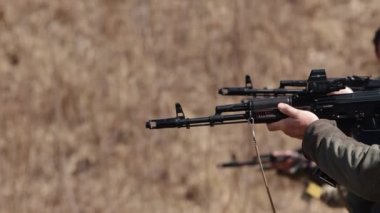 Atış poligonunda, bir adam atış poligonundaki bir hedefe makineli tüfekle ateş ediyor.