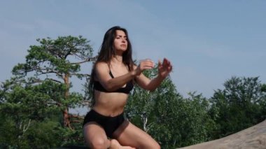 Güzel bir kadın mindere diz çöker, leğen kemiğini ve vücudunu kaldırır. Şafak vakti kayalık arazide genç ve güzel bir bayan antrenman yapıyor. Spor giyim bölümündeki güzel formalı kız dışarıda Rocky 'de egzersiz yaparken..