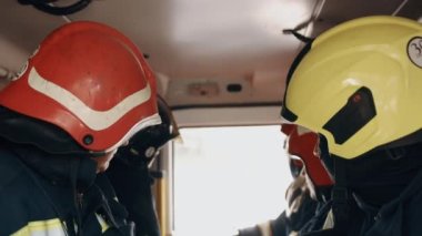 Close up portrait of strong serious firemen in helmet. Indoors. Concept of saving lives, heroic profession, fire safety. Inside the cabin. Catastrophe.