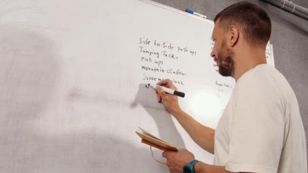 Organiseer Plan Trainingen Een Persoon Een Shirt Schrijft Een Trainingsplan — Stockvideo