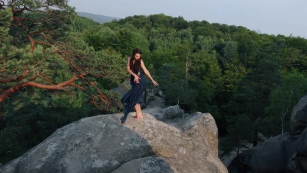 崖の端に青いドレスを着た若い女性 神秘的な写真は バレエダンサーの崖の端に立っている 岩の端に立って美しいガウンを着た女性 — ストック動画