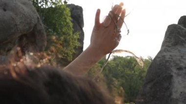 Bir kadının avucunun içinde, güneşin ışığına bakar doğanın güzelliğine hayran olur ve avucunun içini aydınlatmasına hayran kalır..