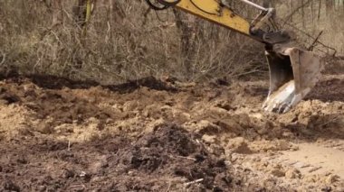 Sürüngen kazıcı. Kova kaldırma ile yapılan tarama inşaat alanında toprak kazıyor. Kazıcı inşaat alanında toprağı kazıyor. Kapat.