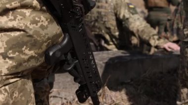 An armed soldier guards an object at a checkpoint with a submachine gun that he has in his possession