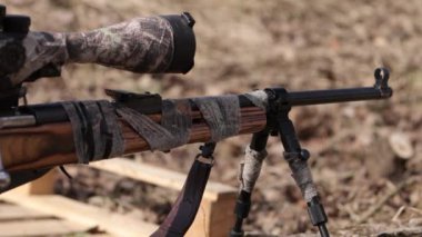 There is a sniper rifle outside in the shooting range that is ready for use
