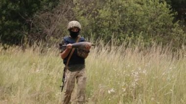 A mortar mine that has not exploded but has been carried by a military soldier in camouflage to neutralization site, clearance of unexploded shells after a battle.