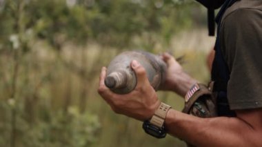 Mortar mine that has not exploded. The clearing of unexploded shells after a battle in war by a soldier in camouflage after carrying unexploded mortar mines.