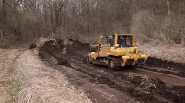 İnşaat makineleri, buldozer yapımı, toprak taşıma makinesi teknolojisi, endüstriyel ereksiyon kavramı. İnşaat alanında çamurda çalışan buldozer.