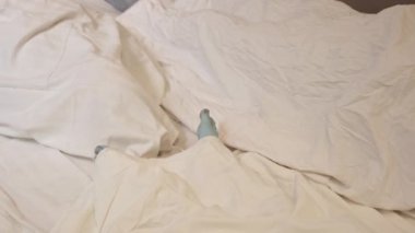 Human corpse covered with a sheet in morgue. Homo dead comprise with sheet. Human corpse covered with bedsheet, in morgue. Death from covid-19 and protection from virus global.