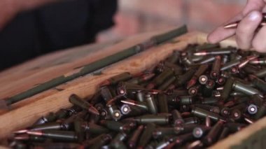 Hand taking ammo, bullets 762 caliber for ak47, gun crime military target war bullet weapon army military firearm, bullet pile, bullet shells, military concept, hunting ammo, close up