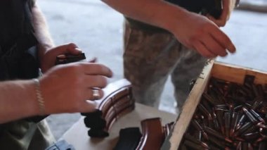 Close-up of hand taking ammo, 7.62 caliber bullets for the Ak47, war bullet weapon, bullet pile, bullet shells, military concept, hunting ammunition.