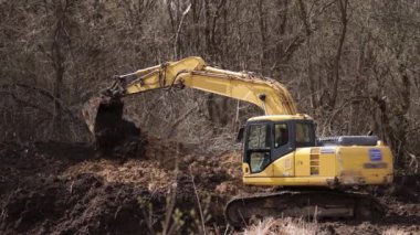 İnşaat alanında çukur kazarak kepçeyle çalışmak. Toprak kazmak için kazıcı kova dişleri. Toprakta sürüngen tarağı kazmak. Kazıcı. Toprak hareket eden araç.