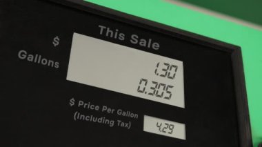 Digital counter count up the counter of a gas pump and rising prices. Gas station fuel meter counter price. Close up while refueling a car. Increasing petrol costs. prices close to five dollars