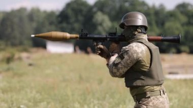 The soldier wears a helmet, military uniform, and body armor while firing a Precision Shoulder-Fired Rocket Launcher RPG-7 PSRL-1 at the enemy.