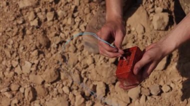 An army soldier, an anti-terrorist team combat engineer, an ammunition technical officer, an explosives military expert, a saboteur in camouflage and a balaclava helmet holding explosives