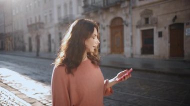 İyimser genç bir kadın telefonda konuşurken heyecanlı, kıvırcık saçlı Amerikalı bir kız akıllı telefonunu kullanıyor, güzel bir kadın dışarıda yürürken cep telefonuyla konuşuyor.