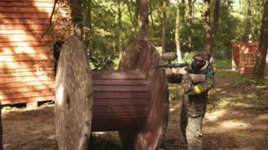 Painting, an action-adrenaline sport, taking part in a leisure activity, paintballing, playing paintball with friends wearing camouflage and protective masks