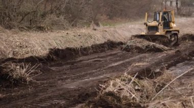 İnşaat makineleri, buldozer yapımı, toprak taşıma makinesi teknolojisi, endüstriyel ereksiyon kavramı. İnşaat alanında çamurda çalışan buldozer.