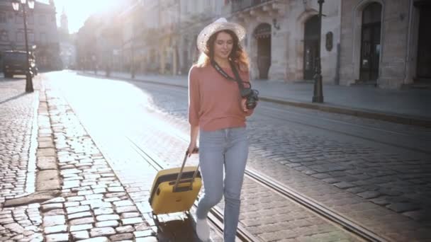 Şehirdeki Eski Binaların Etrafında Tekerlekli Bavulla Gezen Bir Bayan Turist — Stok video