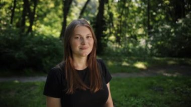 Gün batımında, bir kadın gün batımına bakarken kameraya gülümser, gülümseyen kız da gülerken kameraya bakar..