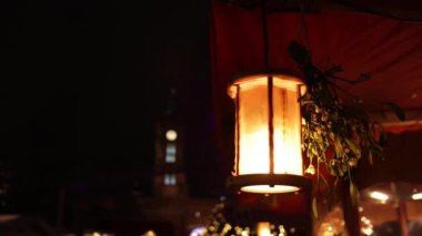 Açık havada aydınlatma, Noel Xmas 'ın akşamları aydınlatma, parlak akkor lambalar bir çelenge karşı çelenk gibi kablolardan sarkıyor, bir çelenkten arka plan, karanlıkta yanan lambalar.