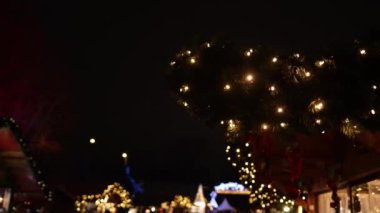 Işık saçan parlak lambalar, arka plandaki kablolarda asılı duran çelenkler gibi. Açık hava ampul dekoru, Noel Xmas akşam aydınlanması, yeni yıl tatili, Noel tatili, çelenk arkaplanı.