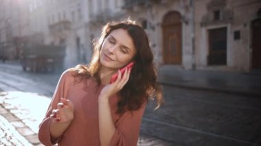 Şehrin sokaklarında, kendine güvenen beyaz kadın işe giderken cep telefonuyla konuşuyor, esmer kadın yol kenarında akıllı telefonu taşıyor, arkadaşlarıyla telefonda konuşuyor, gülüyor, gülümsüyor, dışarıda.