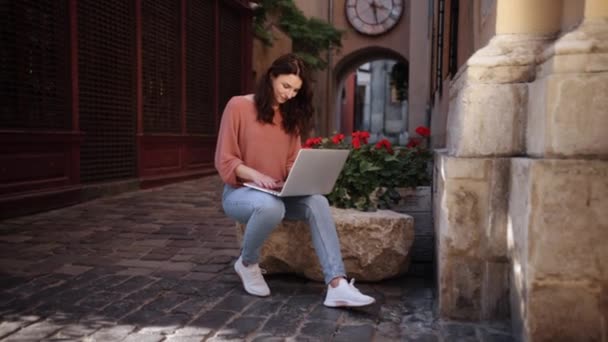 Uma Jovem Mulher Atraente Digitando Laptop Enquanto Senta Pedras Decorativas — Vídeo de Stock