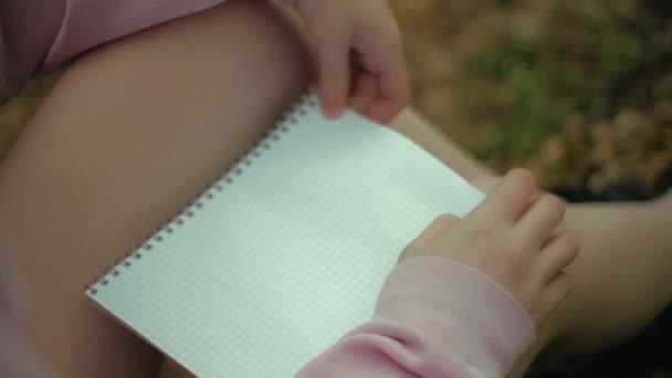 Töprengő ideges nő író az erdőben ül egy üres papír felett, és azt gondolja, — Stock videók