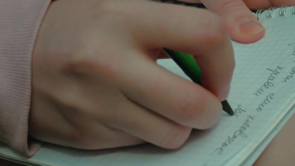 Женская рука спешит пишет стихи на бумаге посреди леса, крупным планом — стоковое видео